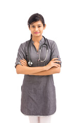 Wall Mural - Attractive crossed hands young Indian female doctor isolated on white.