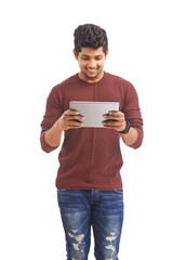 Wall Mural - Handsome Indian young man playing digital tablet on white.