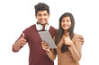 © krishna - Beautiful young couple posing showing hand sign with digital tablet on white.