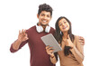 © krishna - Beautiful young couple posing showing hand sign with digital tablet on white.