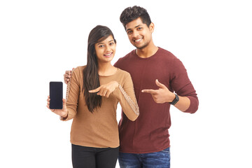 Wall Mural - Beautiful happy young couple holding smart phone on white.