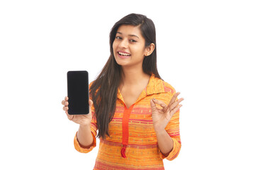 Wall Mural - Cheerful Indian attractive women holding smartphone against White.