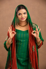 Sticker - Pretty Indian young Muslim girl showing best hand sign studio shot.