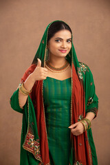 Canvas Print - Pretty Indian young  girl showing thumbs up hand sign.