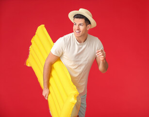 Poster - Young man with inflatable mattress on color background