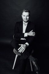 Handsome businessman man sitting on chair in photo studio