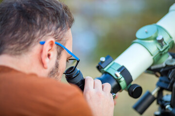 Wall Mural - amateur astronomer looking at the sky with a telescope.