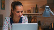 © DC Studio - Tired business woman reading reports sitting in front of laptop late at night working from home. Busy focused employee using modern technology network wireless doing overtime writing, searching.