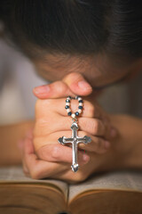 Wall Mural - osary of jesus cross in hands of woman praying for god blessing