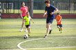 © Blue Jean Images - Happy young family playing football on soccer field