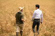 © Blue Jean Images - Farmer talking with businessman in wheat field