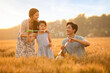 © Blue Jean Images - Happy young family blowing bubbles in wheat field