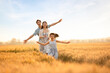 © Blue Jean Images - Happy young family having fun in wheat field