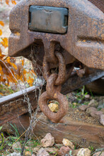 Detail Of The Rusty Chain Holding In Position An Old Rusty Mining Cart On A Rail Track . Close Up. Decoration In The Park.