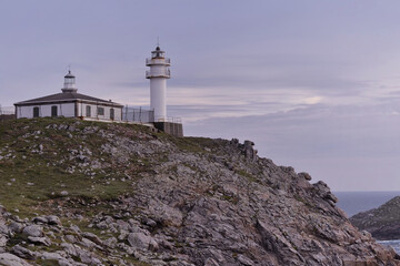 Wall Mural - Tourinan Lighthouse in Muxia, Galician coast, Spain.  Twice a year, at the beginning of spring and the end of summer, Cape Touriñan becomes the last shadow for the sunset in continental Europe.

