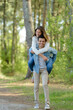 © auremar - young carefree couple piggybacking and having fun among the trees