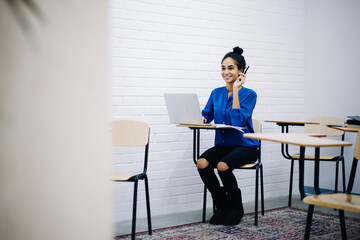 Happy ethnic teenage student with laptop