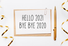 Hello 2021 Bye Bye 2020 Note With Envelope, Pen, Gifts And Gold Ribbon On White Background. Merry Christmas And New Year Concept
