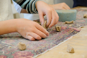 Wall Mural - A child molds a product from clay in a modeling lesson.