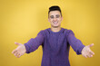 © Irene - Young caucasian man over isolated yellow background looking at the camera smiling with open arms for hug