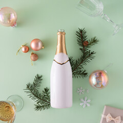 Poster - Creative flat lay with white and gold champagne bottle, fir branches and Christmas decoration against mint green background. Retro aesthetic style. New Year party background.