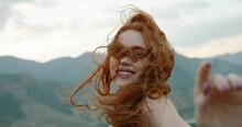 Beautiful Female Model On Top Of A Mountain Posing For Photoshoot, Reaching Her Hand Out To Camera While Wind Blows Her Dress And Red Hair - Freedom, Tranquility 4k Footage