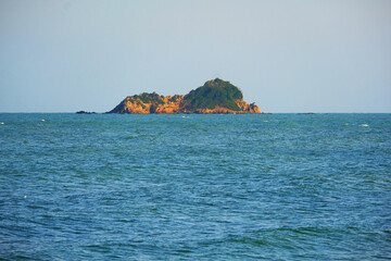 Wall Mural - Sleeping lion island in the sea on blue sky background