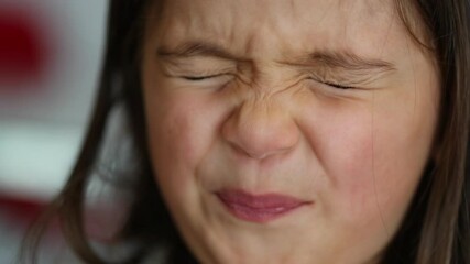 Wall Mural - Little girl closing eyes squinting thinking and opening eyes looking at camera