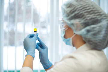 The doctor holds a syringe with medicine in his hands. Vaccination against viral diseases. Prevention and prevention of the coronavirus epidemic