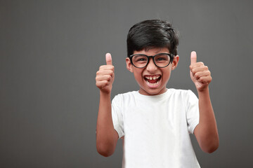 Wall Mural - Cheering little boy shows thumbs up gesture