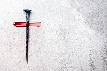 christian cross made with rusty nails, drops of blood on grey background. copy space. good friday, e
