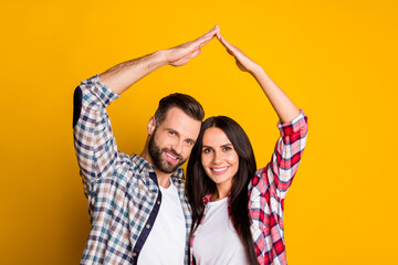 Sticker - Portrait of nice lovely cheery couple showing roof on head good life isolated over bright yellow color background