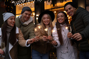 Canvas Print - Group of happy friends with sparklers and champagne at winter fair