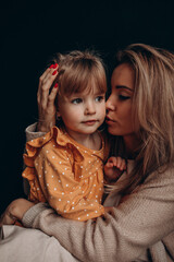 Wall Mural - Young mother with her little daughter. Maternal love for a child. Studio photography.