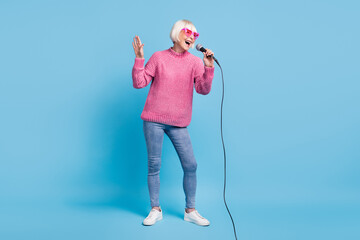 Canvas Print - Photo portrait full body view of old lady singing holding mic in one hand isolated on pastel blue colored background