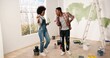 Young cheerful African American couple man and woman hugging and embracing in good mood smiling in apartment during home repair works. Wife and husband renovating house. Remodeling concept