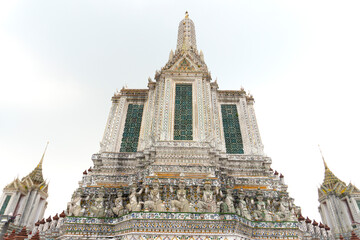 Wall Mural - Close up to the front of the pagoda in Wat Arun Bangkok Thailand Asia, look up shot to the beautiful delicate decoration and design full withBuddhist history of trust and believe