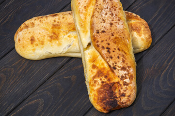 Two baked loaves of Ukrainian national bread on black antique table