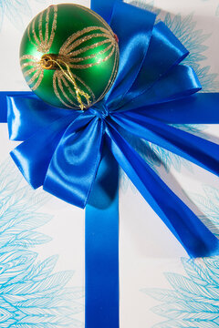 Happy Christmas. Green ball on the blue white gift