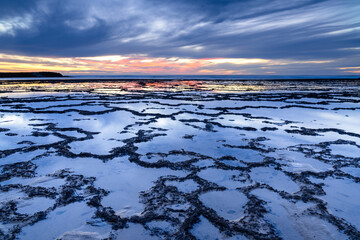 Sticker - beautiful sunset over the ocean with rocky beach and tidal pools in the foreground