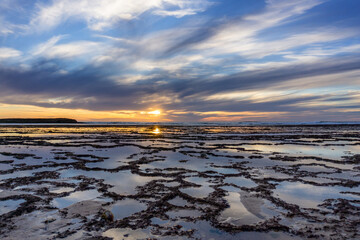 Poster - beautiful sunset over the ocean with rocky beach and tidal pools in the foreground