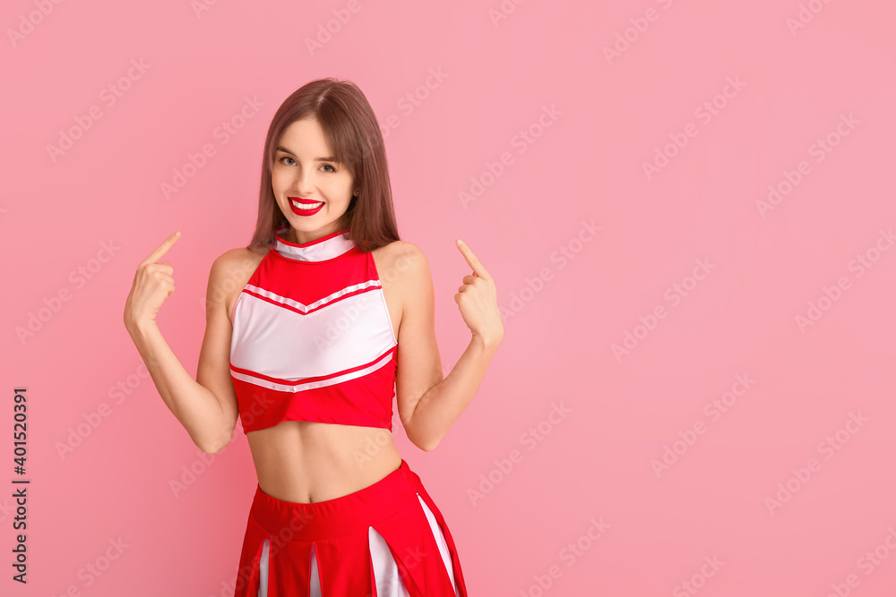Beautiful young cheerleader on color background