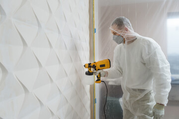 Wall Mural - The painter is painting a 3d wall with a spray gun.