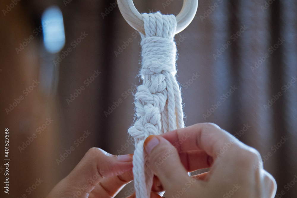 Close-up of a young woman hand tight the rope to making macrame