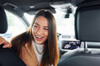 © standret - Driver looks back and smiling. Fashionable beautiful young woman and her modern automobile