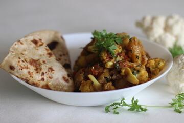 Wall Mural - Spiced potatoes and cauliflower served with flat indian bread