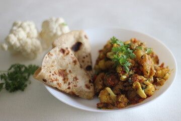 Wall Mural - Spiced potatoes and cauliflower served with flat indian bread