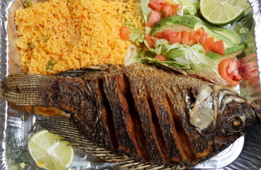 Pescado Frito, a Mexican dish with fried tilapia, yellow rice and salad