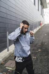 Wall Mural - Vertical shot of a young attractive male standing in the street