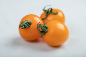 Wall Mural - Yellow tomatoes on light white background, flat lay